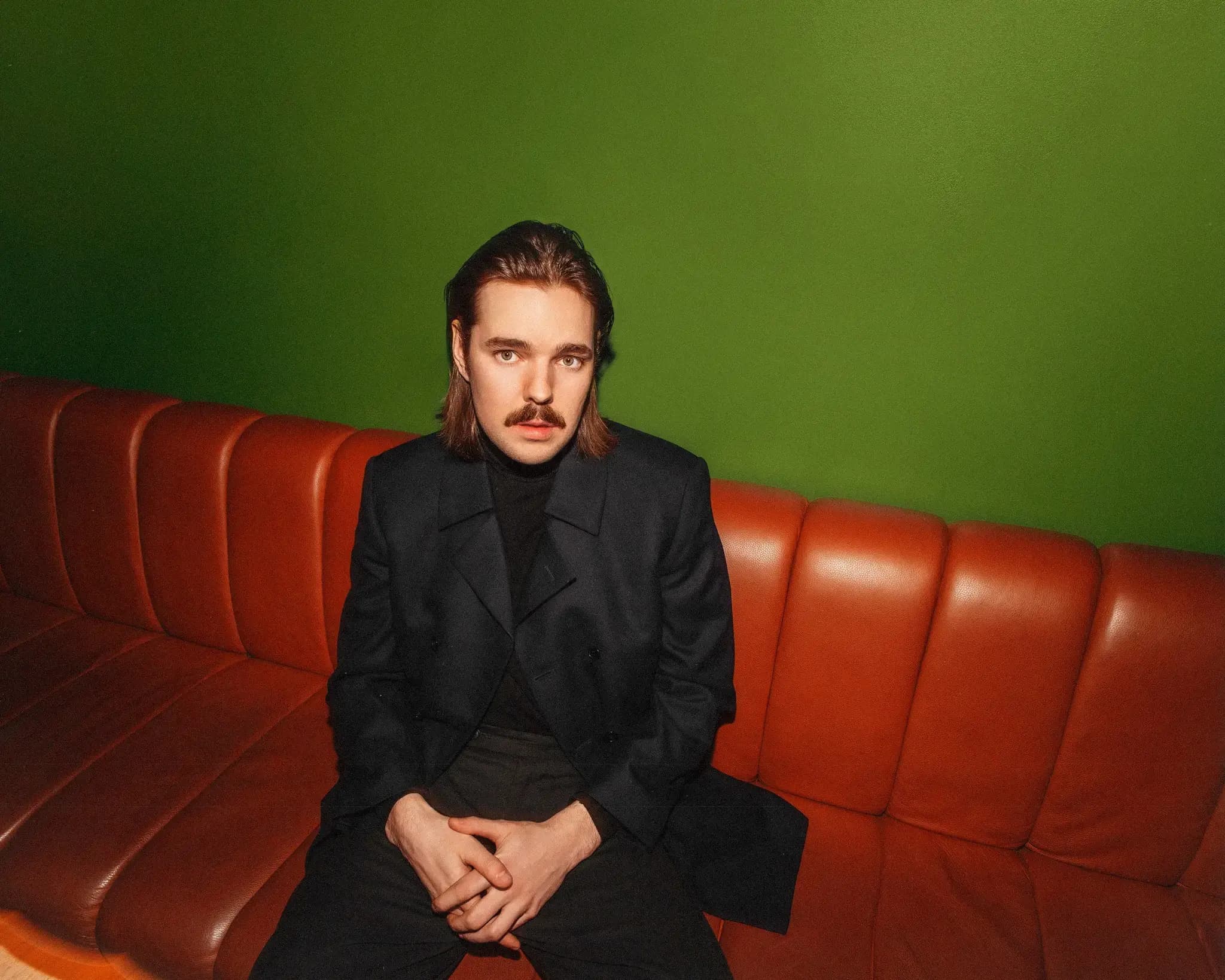 Arppa istumassa punaisella sohvalla